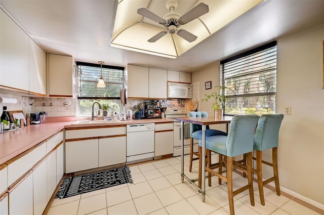 kitchen with white appliances, tasteful backsplash, and white cabinetry