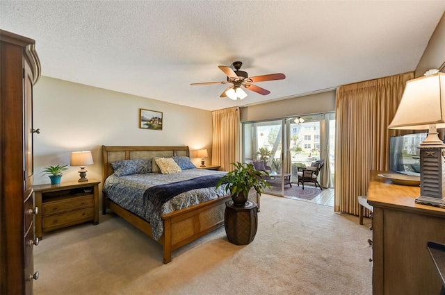 bedroom featuring ceiling fan, light colored carpet, and a textured ceiling