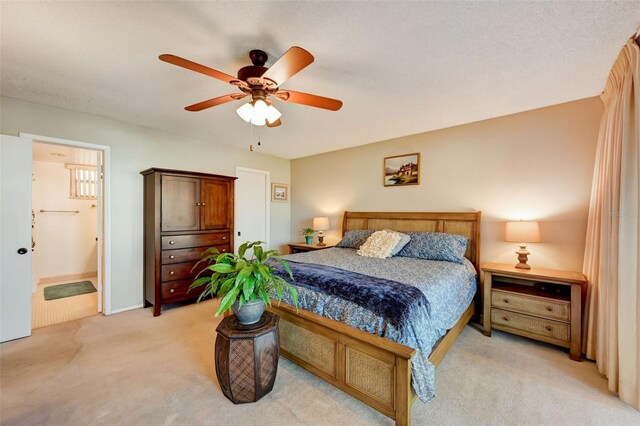 bedroom featuring connected bathroom, ceiling fan, and light carpet