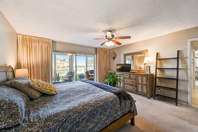 bedroom featuring access to exterior, ceiling fan, light colored carpet, and a textured ceiling