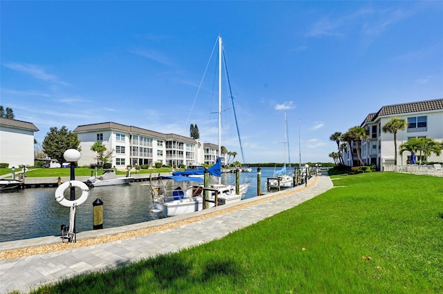 view of dock with a lawn and a water view