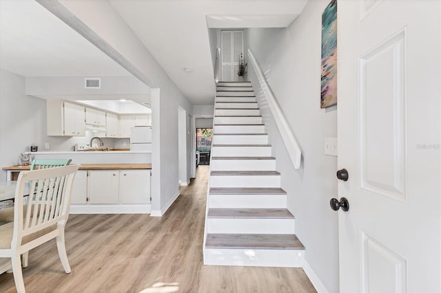 stairway featuring hardwood / wood-style floors and sink