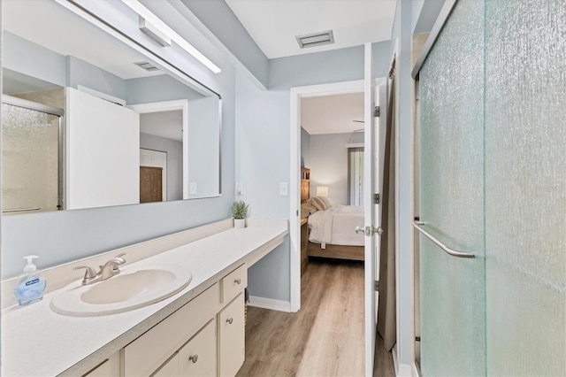 bathroom featuring hardwood / wood-style floors, vanity, and a shower with door