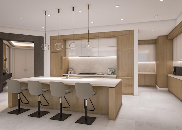 kitchen with sink, decorative light fixtures, an island with sink, and decorative backsplash