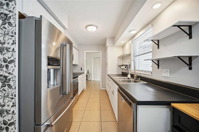 kitchen with white cabinetry, sink, light tile patterned floors, and stainless steel appliances