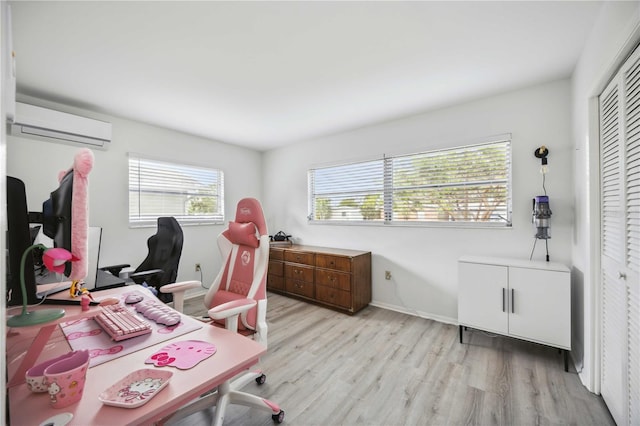 home office featuring light wood-type flooring and a wall unit AC