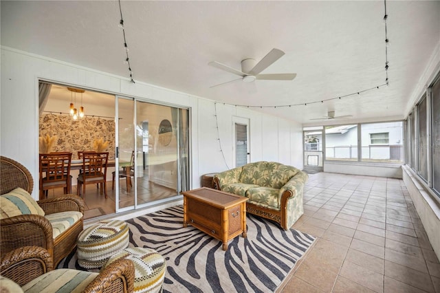 sunroom / solarium featuring ceiling fan with notable chandelier