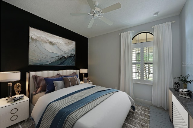 bedroom featuring a ceiling fan, light carpet, a textured ceiling, and baseboards