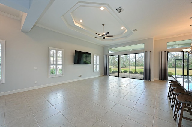 spare room with visible vents, a ceiling fan, ornamental molding, a wealth of natural light, and light tile patterned flooring