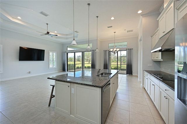 kitchen with open floor plan, appliances with stainless steel finishes, an island with sink, and white cabinets