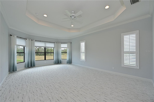 spare room featuring light carpet, baseboards, visible vents, and a raised ceiling