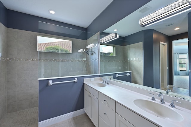 bathroom with double vanity, visible vents, tile patterned floors, a walk in shower, and a sink