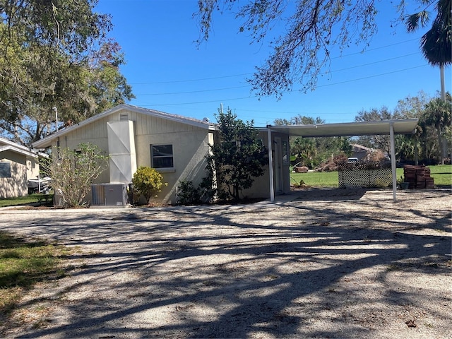 view of side of property with cooling unit and a carport