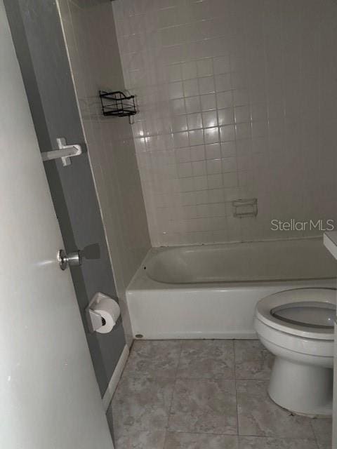 bathroom with tiled shower / bath combo and toilet