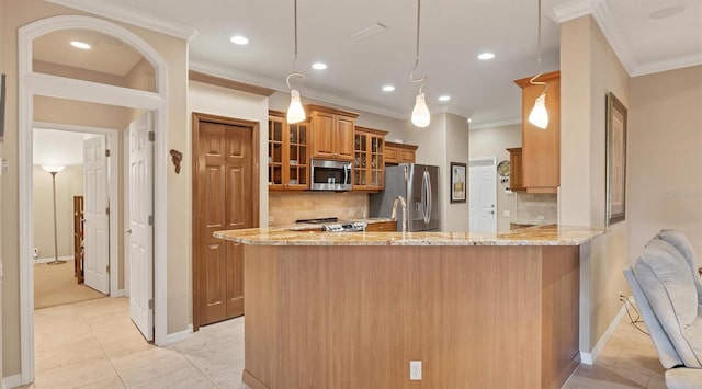 kitchen featuring decorative backsplash, kitchen peninsula, stainless steel appliances, and decorative light fixtures