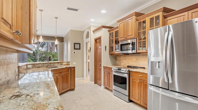 kitchen with decorative backsplash, appliances with stainless steel finishes, light stone counters, crown molding, and pendant lighting