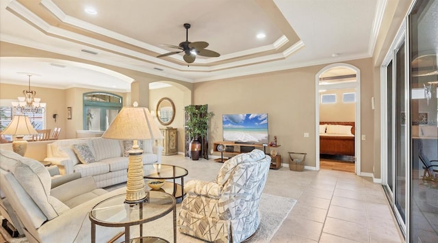 tiled living room with a raised ceiling, ceiling fan with notable chandelier, and ornamental molding