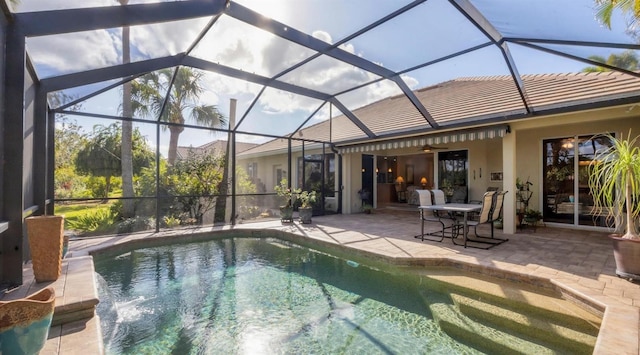 view of pool with glass enclosure, ceiling fan, and a patio