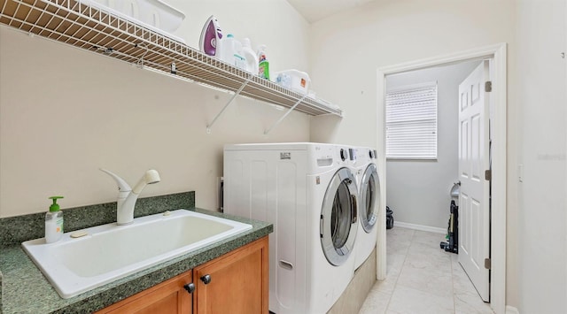 clothes washing area featuring separate washer and dryer and sink