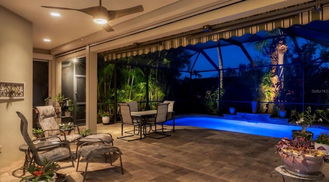 patio at twilight featuring ceiling fan and a lanai