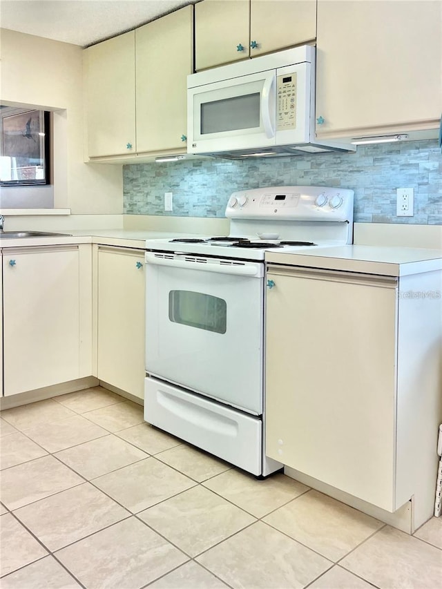 kitchen with light tile patterned floors, white appliances, and backsplash