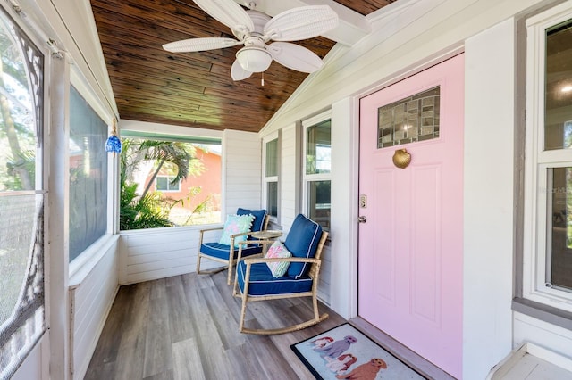 sunroom / solarium with lofted ceiling, ceiling fan, and wood ceiling