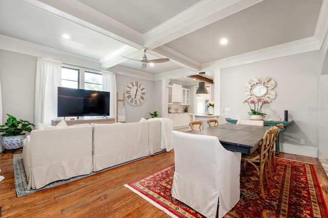 dining area with ornamental molding, coffered ceiling, ceiling fan, beamed ceiling, and hardwood / wood-style floors