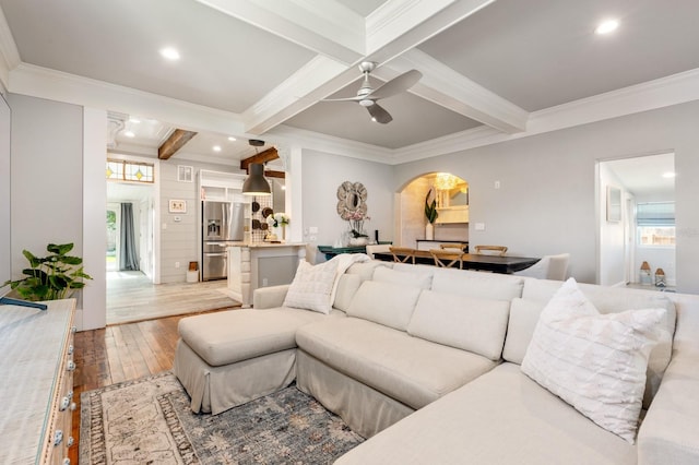 living room with beamed ceiling, ceiling fan, crown molding, and hardwood / wood-style flooring