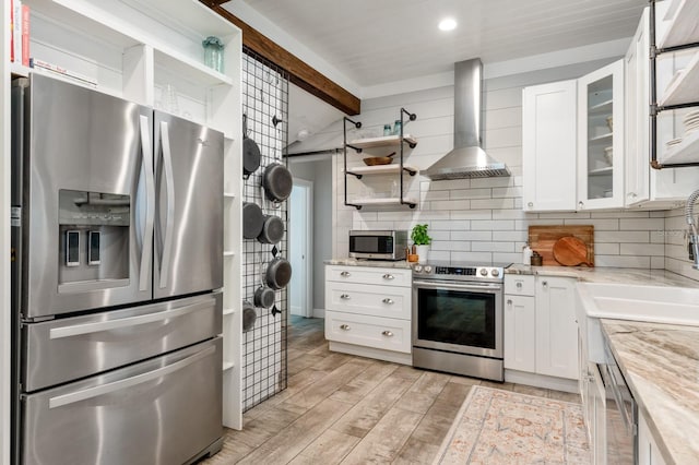 kitchen featuring white cabinets, ventilation hood, stainless steel appliances, and light stone countertops