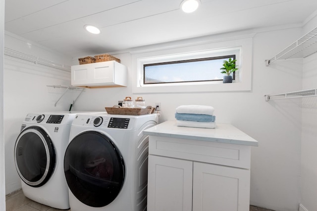 washroom featuring washer and clothes dryer and cabinets