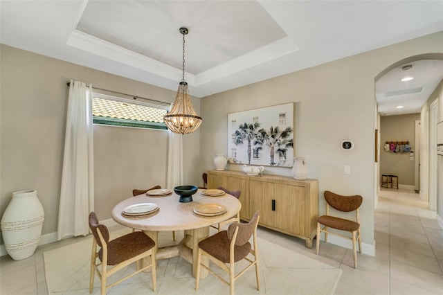 tiled dining area featuring a notable chandelier and a raised ceiling