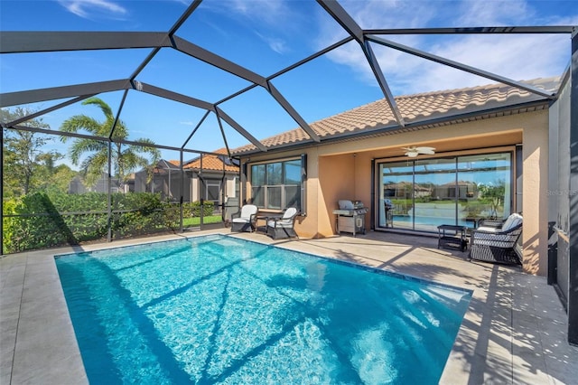 view of pool with ceiling fan, a grill, a lanai, and a patio area