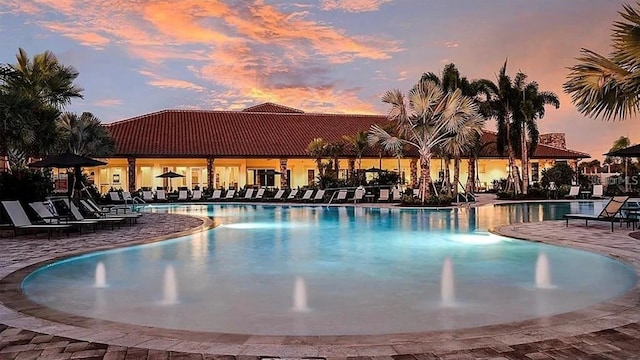 pool at dusk featuring a patio area