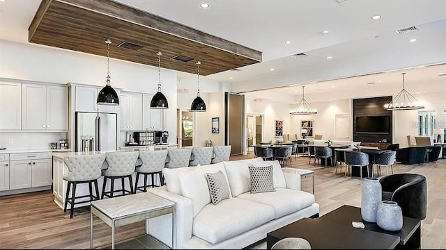 interior space with beamed ceiling, light wood-type flooring, wooden ceiling, and an inviting chandelier