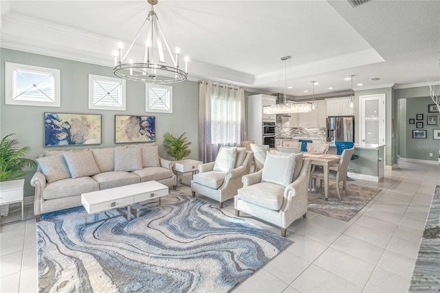 tiled living room featuring a tray ceiling, crown molding, plenty of natural light, and an inviting chandelier