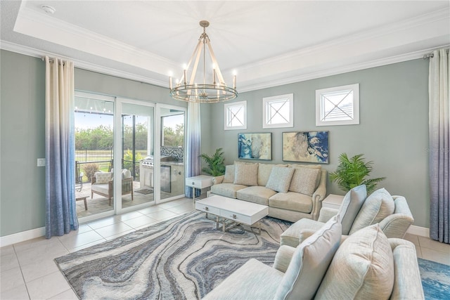 tiled living room with a tray ceiling, ornamental molding, and an inviting chandelier