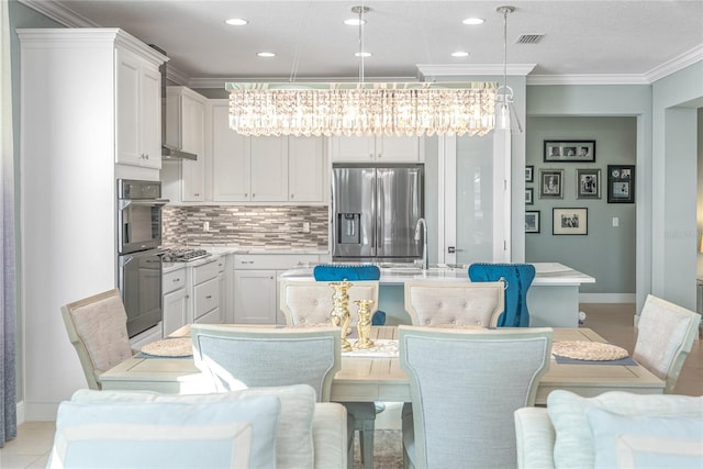 dining area featuring sink, crown molding, and an inviting chandelier