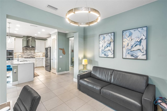 living room featuring sink and light tile patterned floors