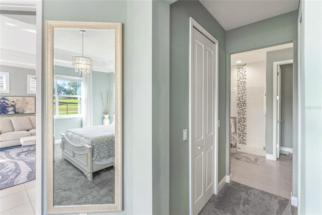 corridor featuring light tile patterned floors, ornamental molding, and a chandelier