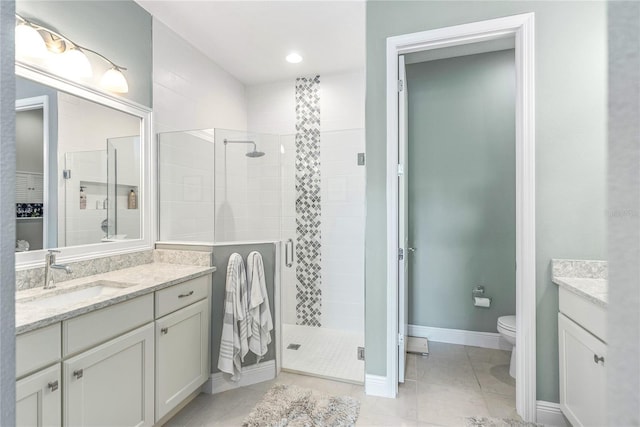 bathroom featuring tile patterned flooring, vanity, toilet, and walk in shower