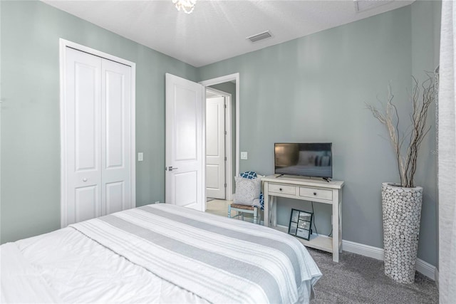 carpeted bedroom with a closet and a textured ceiling