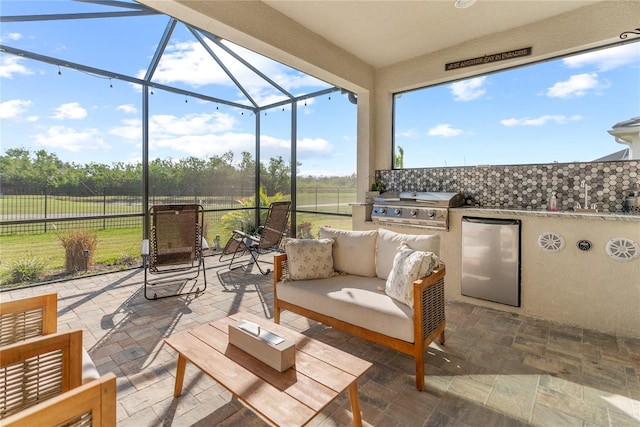 view of patio with glass enclosure, an outdoor living space, area for grilling, and exterior kitchen