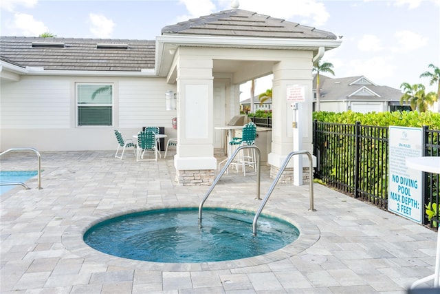 view of pool featuring a gazebo, a community hot tub, and a patio