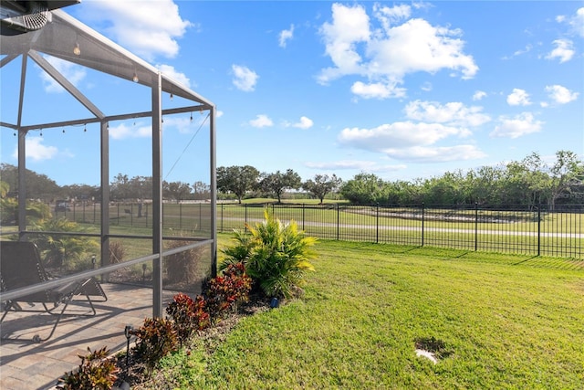 view of yard with a lanai and a rural view