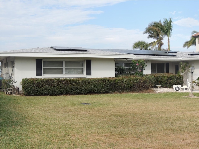 single story home with solar panels and a front lawn