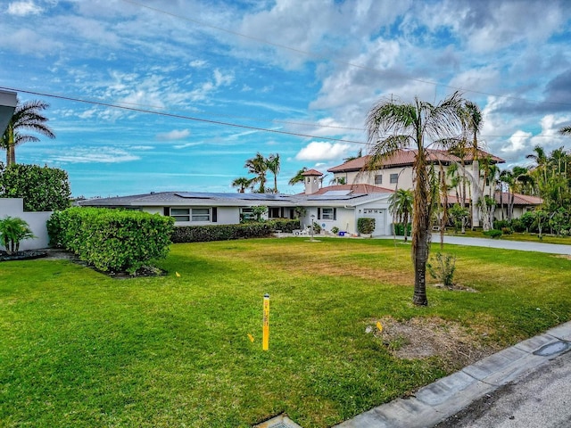 view of front facade with solar panels and a front lawn