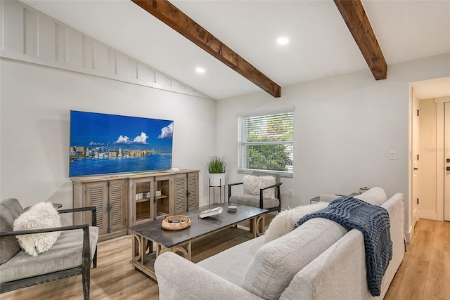 living room with vaulted ceiling with beams and light wood-type flooring