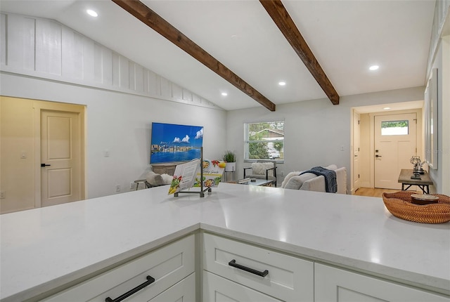 kitchen featuring white cabinets, vaulted ceiling with beams, and hardwood / wood-style floors