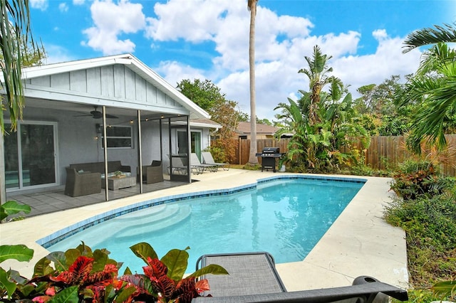 view of pool with grilling area, a sunroom, ceiling fan, and a patio