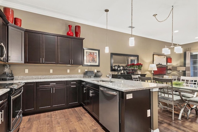 kitchen featuring ornamental molding, stainless steel appliances, sink, dark hardwood / wood-style floors, and hanging light fixtures